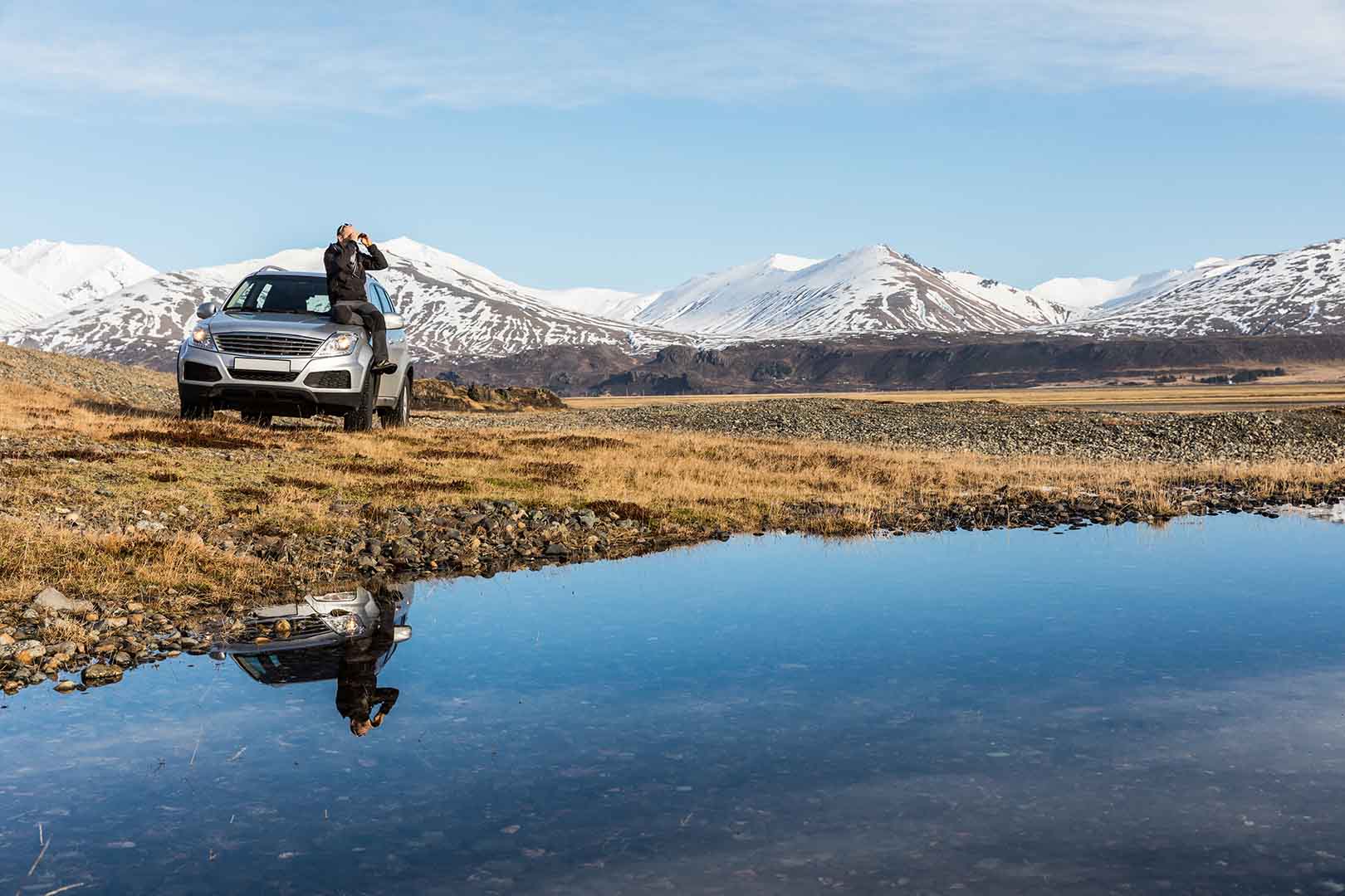Man explorer in Iceland sitting on the car
